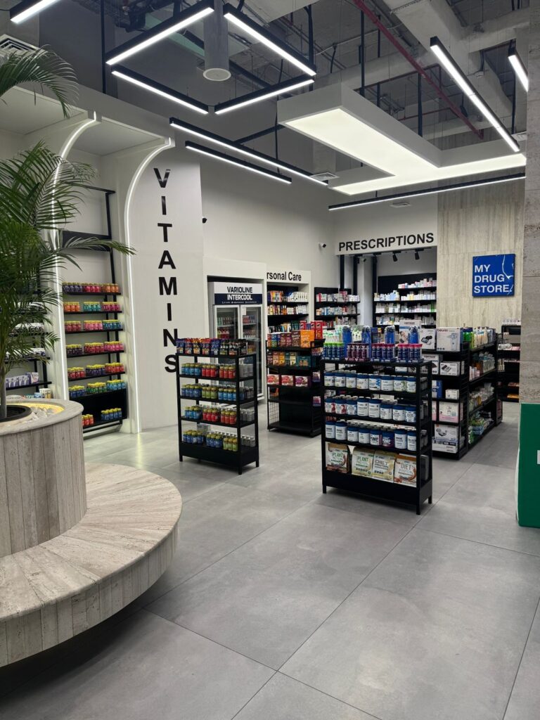 A vitamins and wellness aisle within "My Drug Store" pharmacy in Lahore, designed by ZM Architects with arched signage and layered shelving.