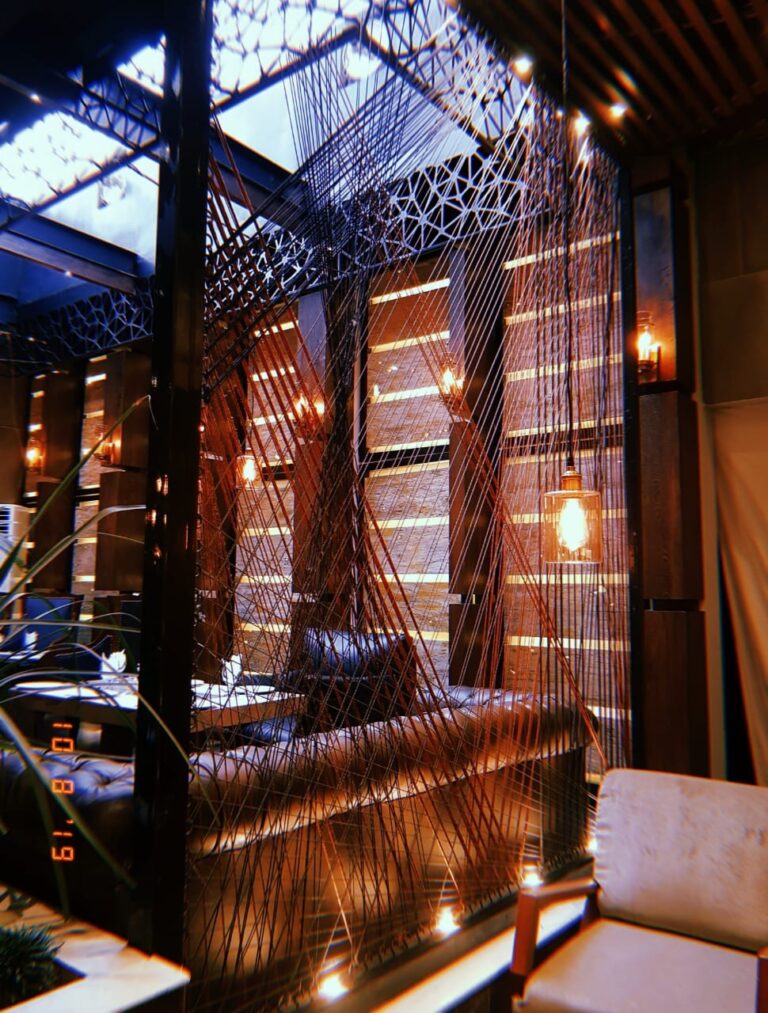 A restaurant lounge combining woven rattan screen panels with natural skylight illumination, designed by ZM Architects.