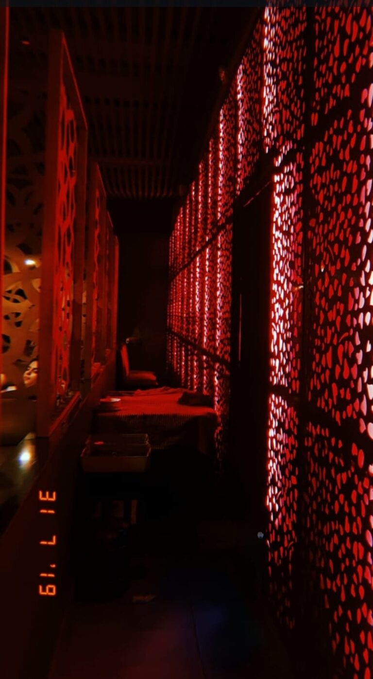 A restaurant corridor in Lahore lined with red perforated metal screen panels, designed by ZM Architects.